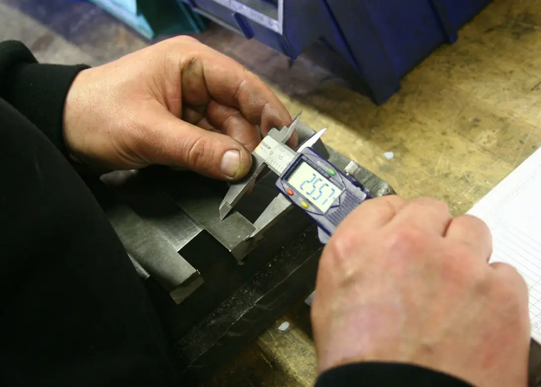 Measuring a metal part with a digital caliper